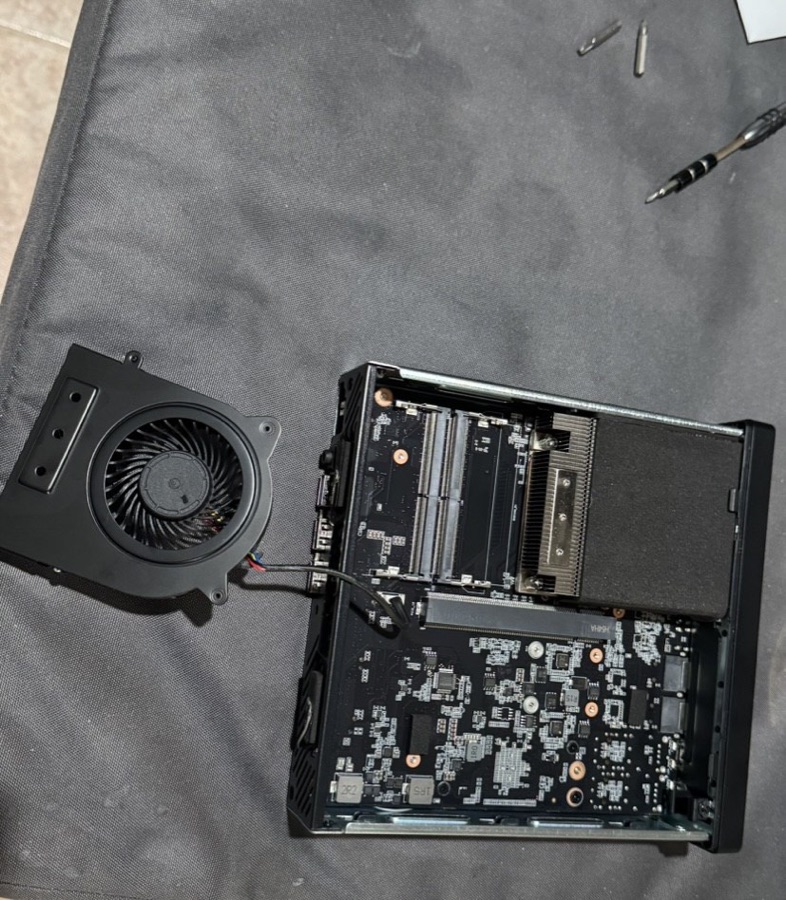 MS-01 open on desk, fan detached, motherboard exposed