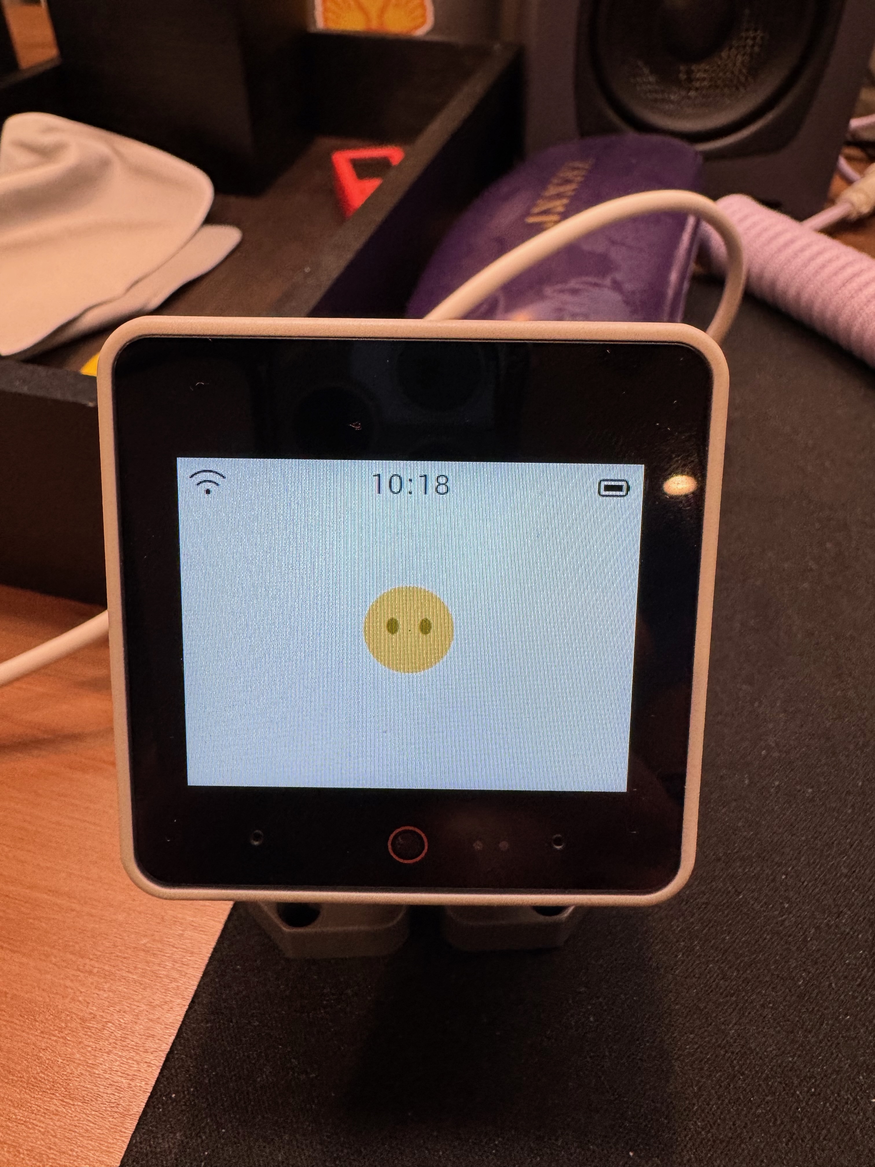 StackChan on a workbench showing the original yellow smiley face before the custom avatar bake.